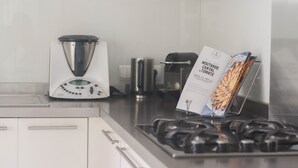A kitchen with a gas stove, a coffee maker, and a cookbook on the counter. - Peaceful Villa with Infinity Pool, 10' from Center (Antibes)