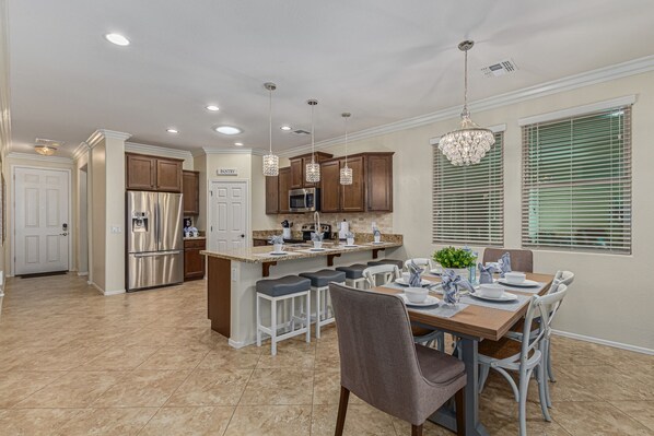 A modern kitchen with a central island, stainless steel appliances, and pendant lighting.