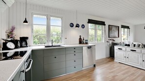 A kitchen with white cabinets, a dishwasher, and a large window.