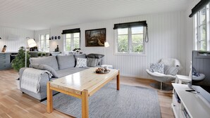 A modern living room with a sofa, coffee table, and a television.