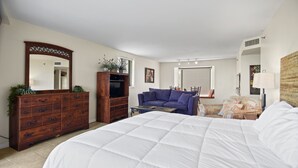 A bedroom with a large bed, a wooden dresser, a sofa, and a television. - Sandestin Beachside II Oasis (Miramar Beach)