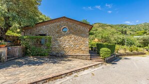 A stone building with a tiled roof, a circular window, and a paved entrance area. - Local Stone Cottage With Shared Pool, Casal Velino, Italy (Casal Velino)