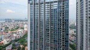Ein Hochhaus mit moderner Architektur, das mehrere Balkone und große Fenster aufweist.