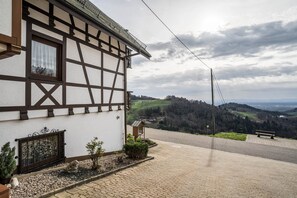 Un bâtiment traditionnel à colombages offrant une vue sur une vallée.