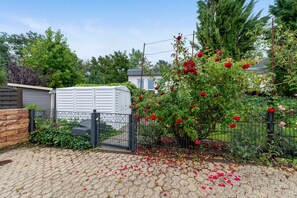 A garden with a rose bush, a shed, and a fence. - Apartment 'Bei Annemarie' with Private Terrace, Private Garden and Wi-Fi (Trier)