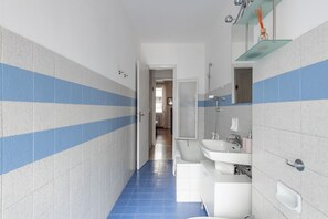 Tina con regadera, secadora de cabello, bidet, toallas 