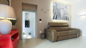 Ein modernes Wohnzimmer mit einer Couch, einem roten Schrank, einer Lampe und einem Wandbild.