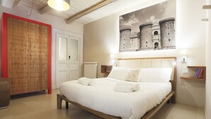 Ein Schlafzimmer mit einem großen Bett, einem Holz-Kopfteil, einer Wandbehange und einer Schreibtafel mit rotem Rahmen.