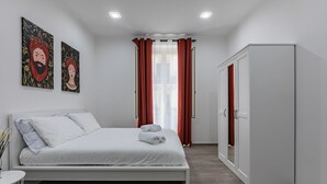 Ein modernes Schlafzimmer mit einem Bett, einem Kleiderschrank und zwei Wandbildern.