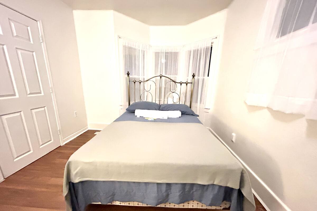 Une chambre à coucher avec un lit, des rideaux et une porte.