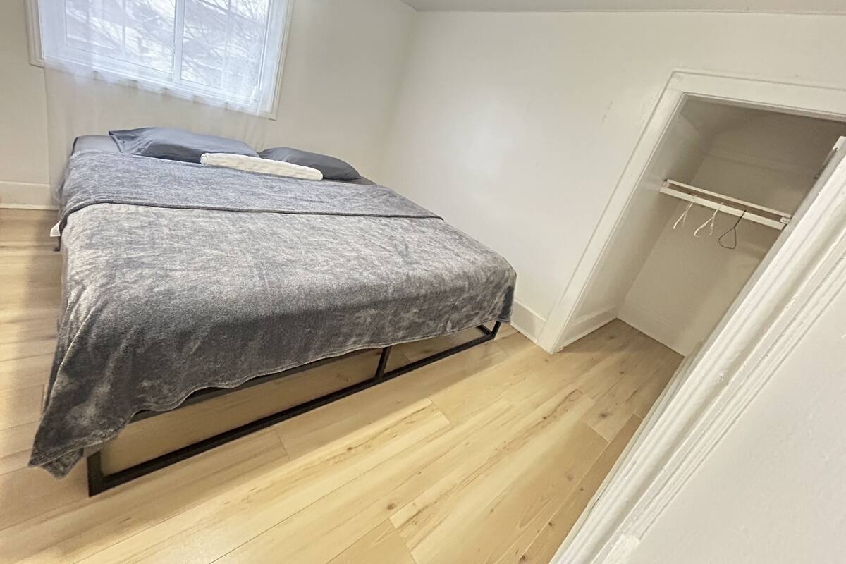 Une chambre à coucher avec un lit, une fenêtre et un placard.