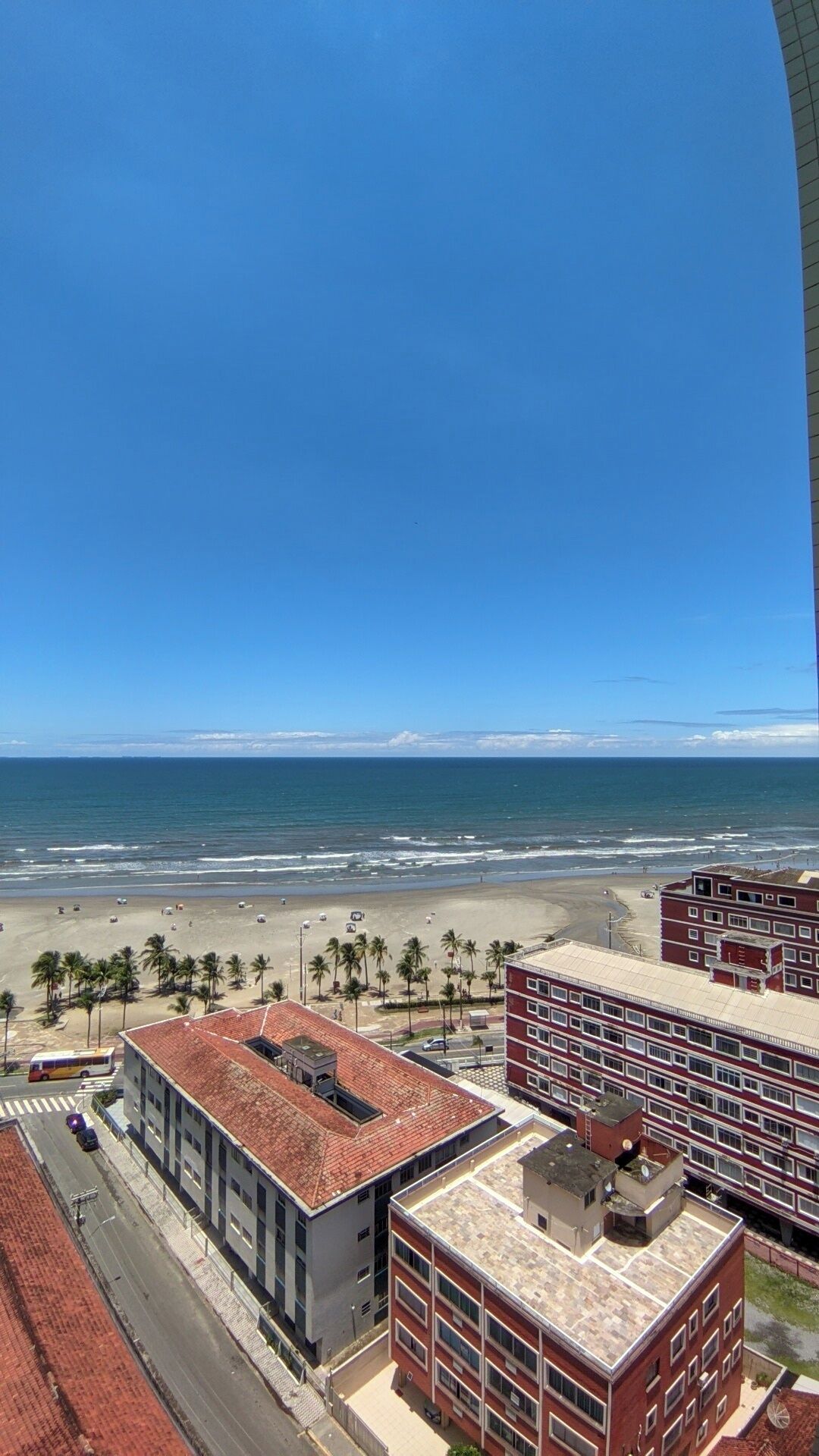 Vista costera con edificios, una playa y cielo despejado.