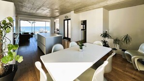 A modern kitchen with a central island, wooden flooring, and a view of the sea. - Air-conditioned villa for 7 people with sea view, rooftop, and beach access in Hyères (HYERES)