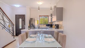 A modern kitchen with a central island, stainless steel appliances, and pendant lighting. - LUX 2BR Condo | Gold Coast Pools & Gym Near Malmok (Noord)