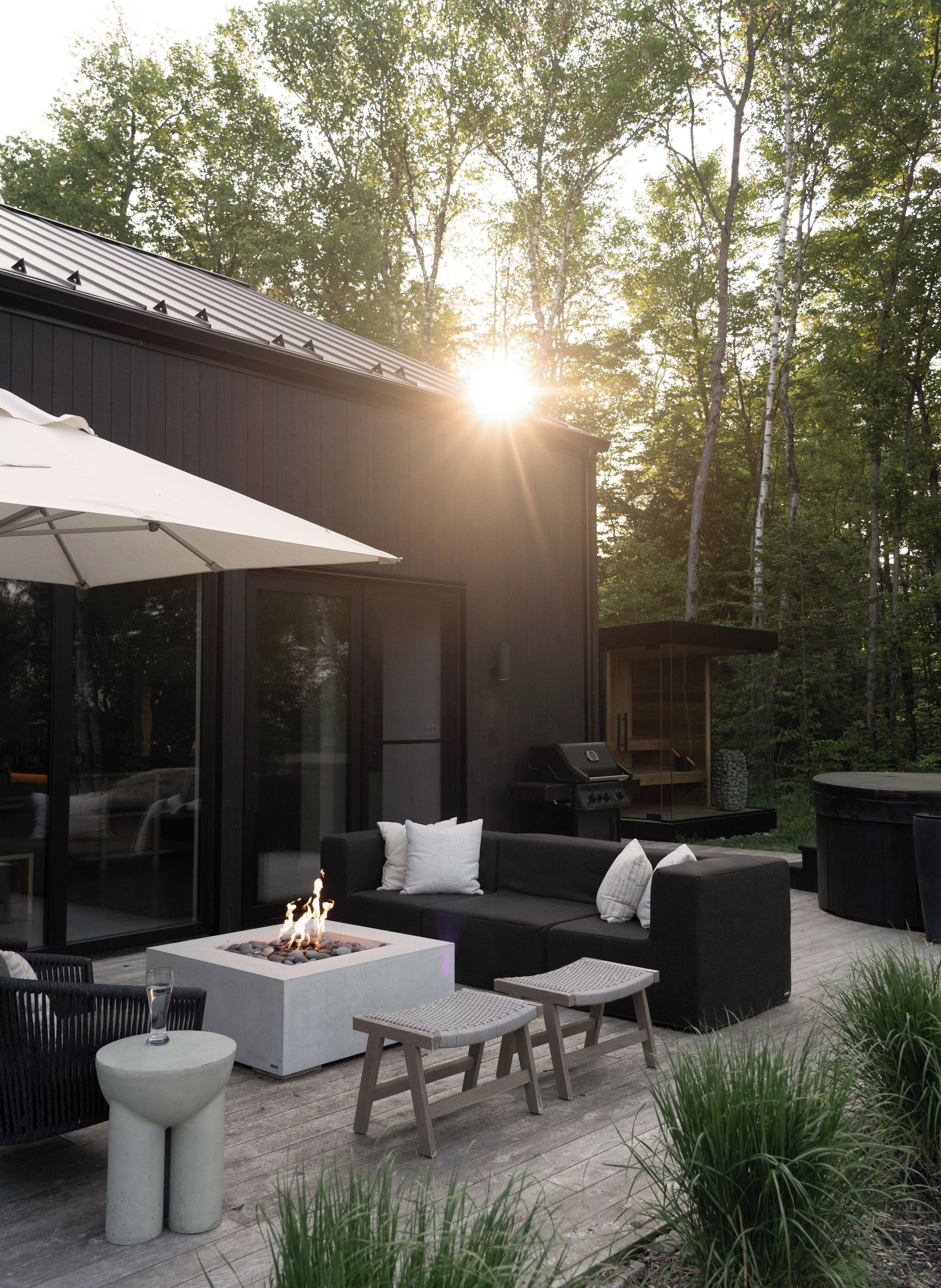 Une terrasse extérieure avec un foyer, des sièges et un espace barbecue.