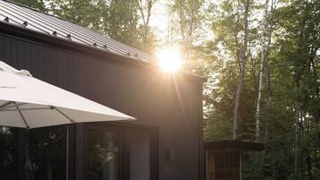 Une terrasse extérieure avec un foyer, des sièges et un espace barbecue.