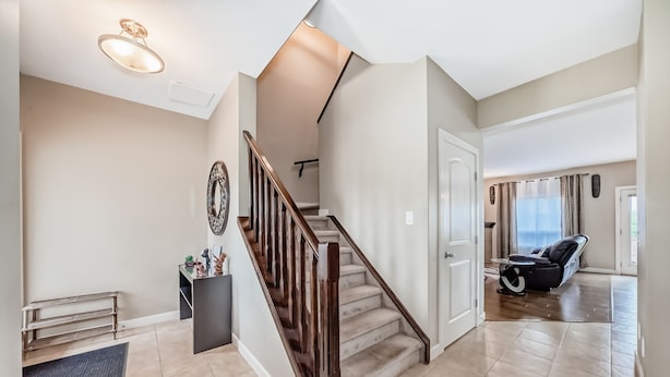 A spacious living area with a wooden staircase, a bench, and a seating area with a massage chair. - Rome, Sweet Home. 

Spacious 4 Bedroom Single detached house - 60 mins to Banff. (Calgary)
