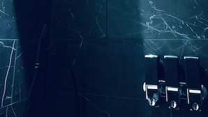 Un bagno moderno con un soffione doccia, un asciugamani ad aria e un erogatore di sapone.