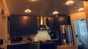 Una cucina moderna con mobili scuri, un frigorifero in acciaio inossidabile e un forno integrato.