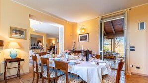 Un comedor con una mesa dispuesta para cuatro, sillas, una lámpara y vistas al exterior.