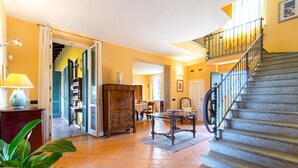 Un salón espacioso con escalera, comedor y vistas al exterior.