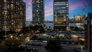 Un paysage urbain avec des immeubles modernes de grande hauteur, un parking et une zone riveraine.