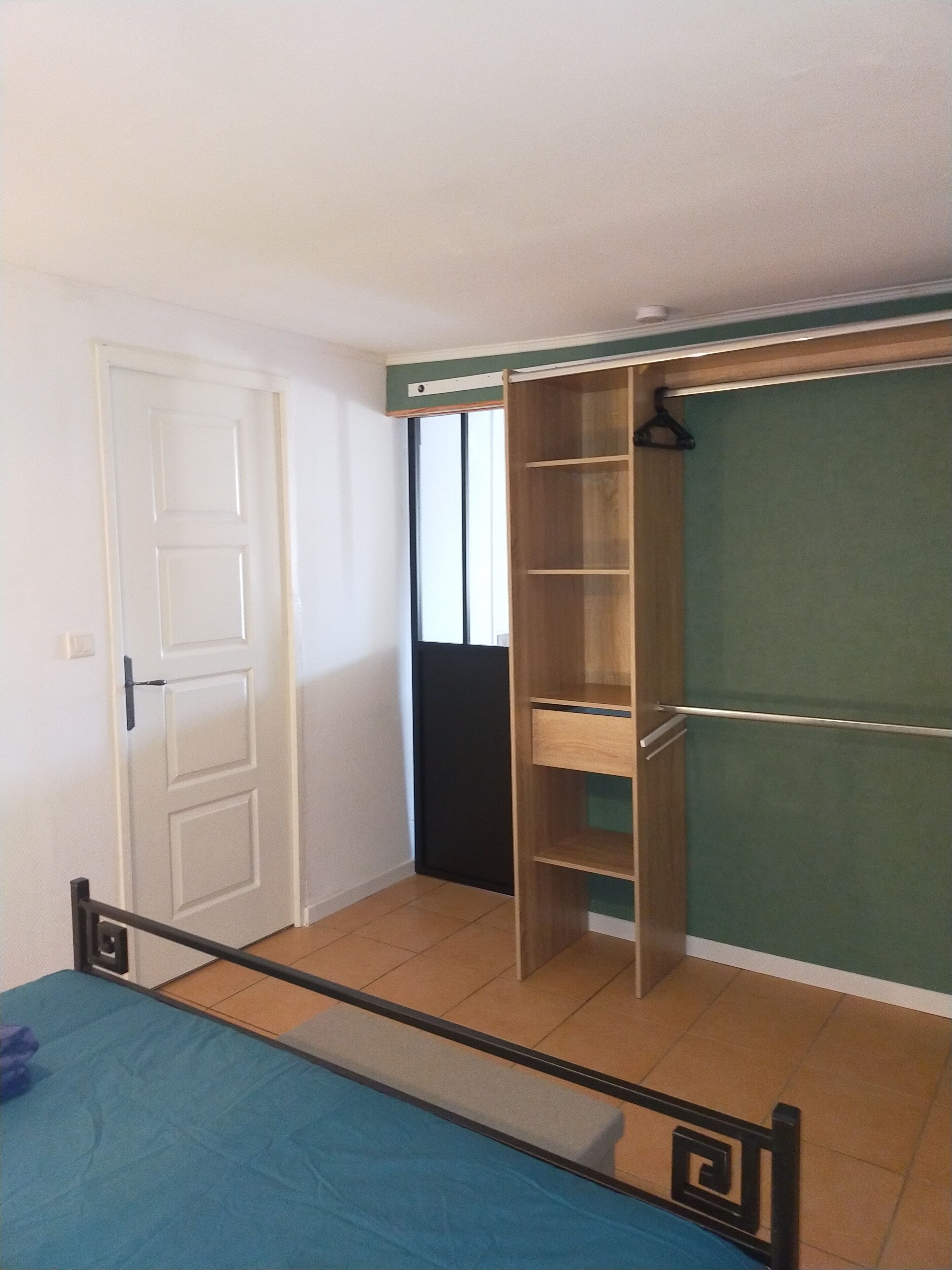 Une chambre à coucher avec un lit, une armoire et une porte.