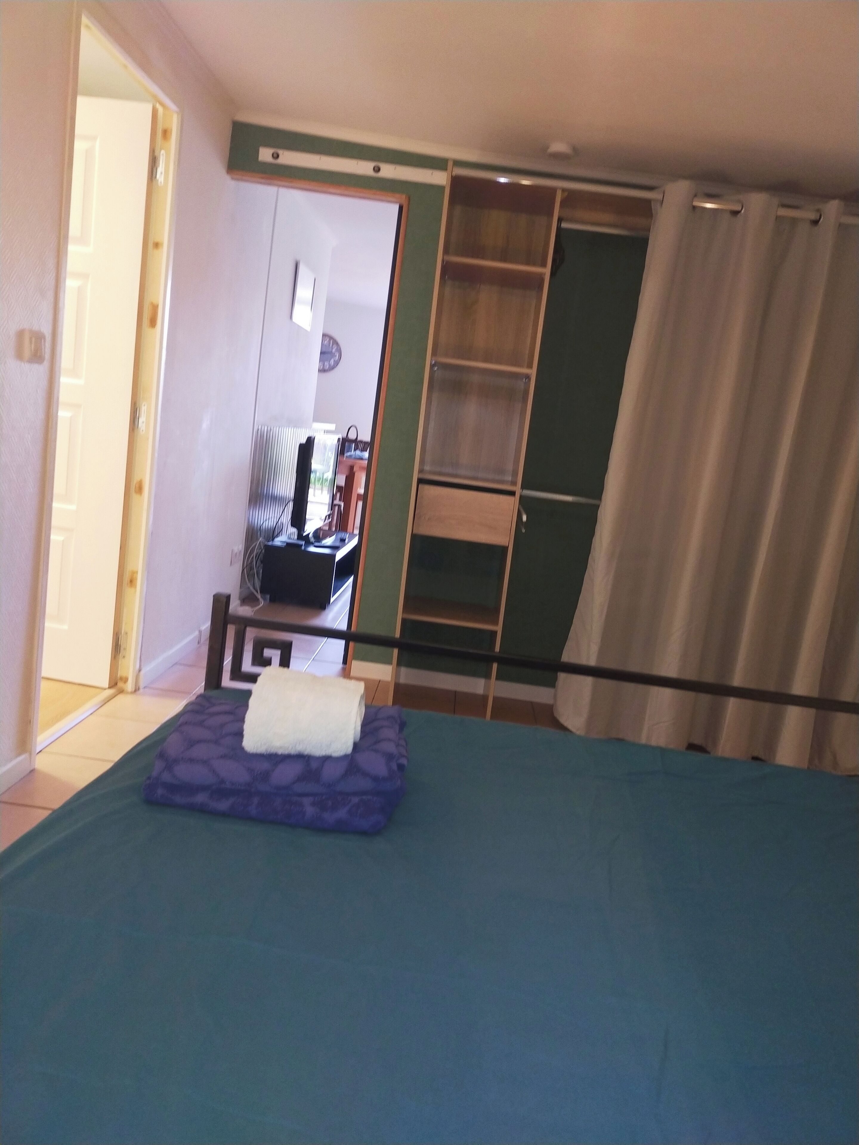 Een slaapkamer met een bed, een bureau, een stoel en een kledingkast.