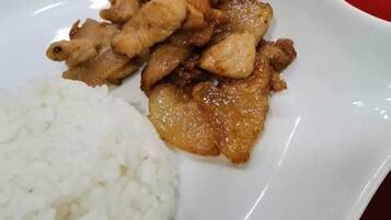 A plate with fried chicken and white rice.