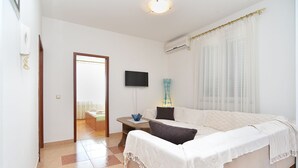 A hotel room with a bed, a small table, a TV, and a window with curtains. - Apartment 2224/67730 (Istria - Rovinj), 800m from the beach (Rovinj)