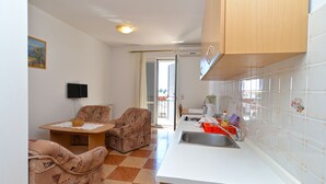 A compact kitchen with a dining area, a television, and a view to the outside. - Apartment 2224/67738 (Istria - Rovinj), 800m from the beach (Rovinj)