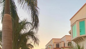 A residential building with multiple balconies, surrounded by well-maintained gardens and palm trees. - Mirpur Apartments & Hotel (Mirpur)