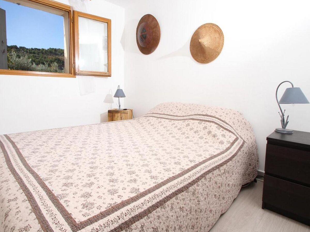 A bedroom with a bed, bedside tables, a window, and wall decorations.