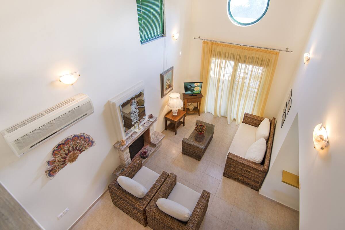 A spacious living area with a fireplace, a television, and a comfortable seating arrangement.