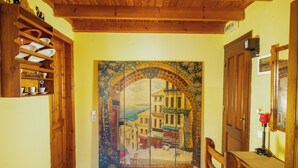 A hallway with a mural, wooden furniture, and a door marked 'EXIT'. - Symi Garden Studios (Symi)