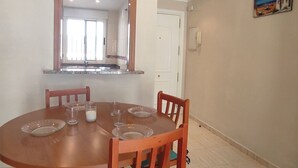 Un comedor con una mesa redonda, sillas y un espejo sobre la mesa.