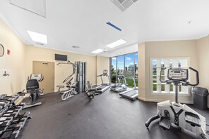 A gym with treadmills, elliptical machines, and free weights. - Plantation Dunes Condos (Gulf Shores)