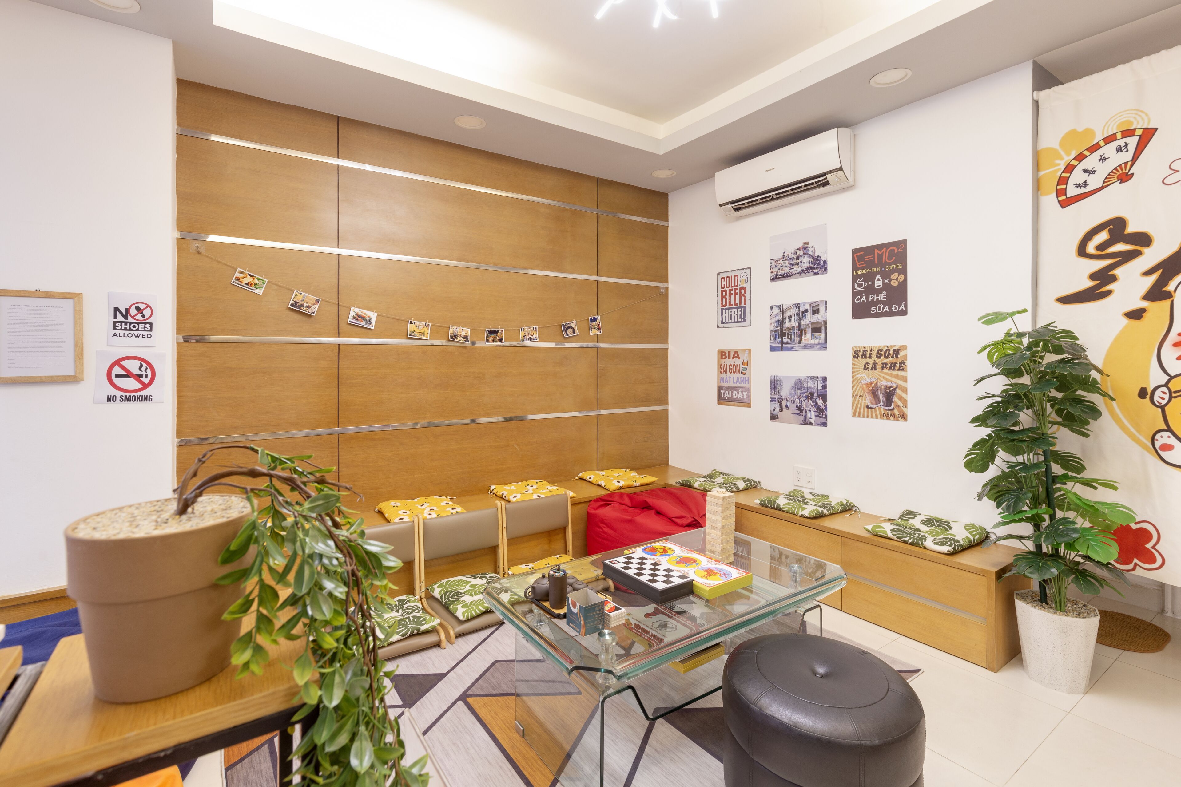 A modern waiting area with a glass table, seating, and a wall displaying photos and a clock.