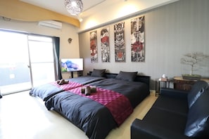 Ett hotellrum med en stor säng, en soffa, en tv och konstverk på väggen.