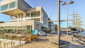 A modern hotel with a rooftop terrace, outdoor seating, and a view of the marina. - Cozy home in Lübeck with house sea view (Lübeck)