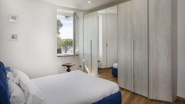 Une chambre moderne avec un grand lit, une armoire et une petite table.