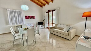Un salón amplio con mesa de comedor, sillas, sofá y televisor.