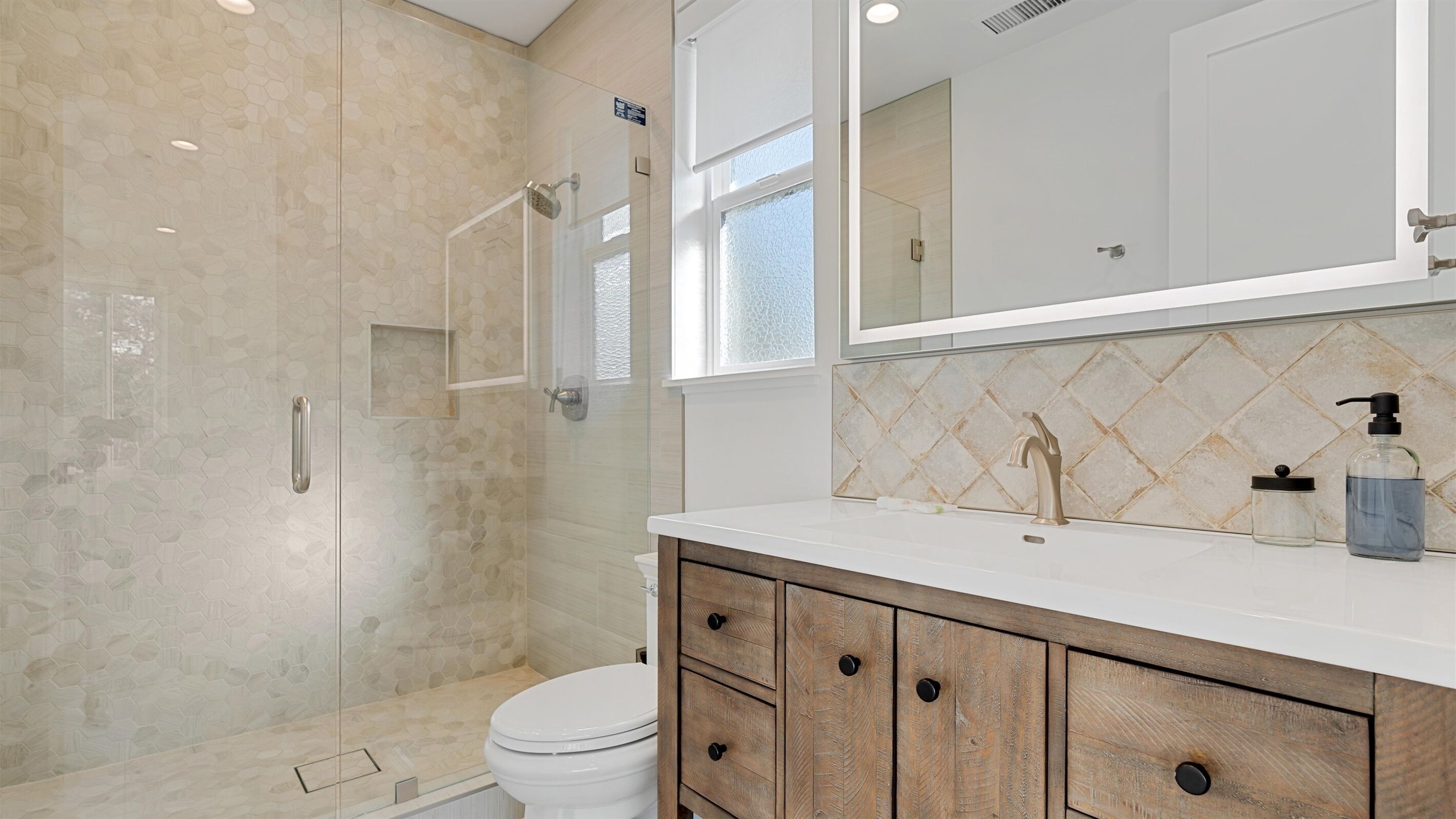 Une salle de bain avec douche, toilettes et meuble-lavabo avec tiroirs.
