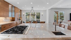 A spacious kitchen with a large island, wooden cabinets, and a modern pendant light. - Healdsburg Luxe Reserve for 8, pool, spa, firepit (Healdsburg)