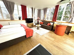 Panoramastudio | Living area | Flat-screen TV, books - Boutiquehotel Hubertushof (Bad Ischl)