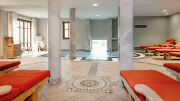 Relax by the pool surrounded by comfortable loungers and a stylish floor design.