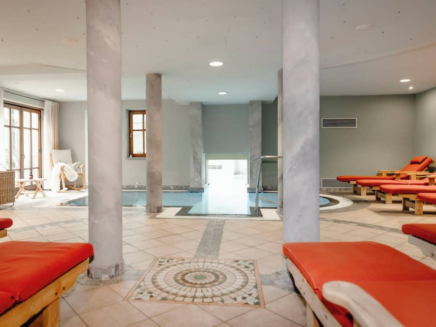 Una piscina techada, sillones reclinables de piscina