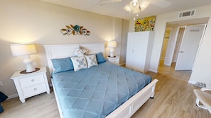 A bedroom with a bed, two bedside tables, a wardrobe, and a painting on the wall.