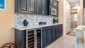 A modern kitchen with dark cabinets, a microwave, and a coffee maker. - Coral Breeze  | Sunshelf | 4 Bed, 3 Bath (Rotonda West)