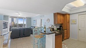 Eine moderne Küche mit Holzausstattung, einer Bar und einem Essbereich mit einer Couch und Sesseln.